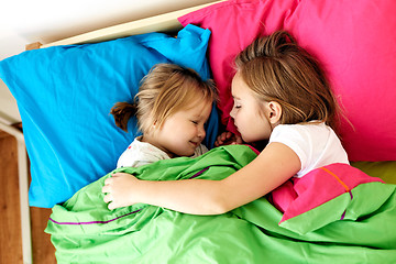 Image showing happy little girls sleeping in bed at home