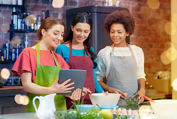 Image showing happy women with tablet pc cooking in kitchen