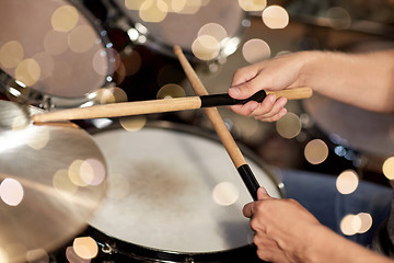 Image showing male musician hands with drumsticks at concert