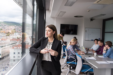 Image showing Business Girl Standing In A Modern Building Near The Window With