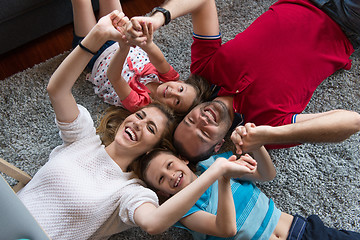 Image showing happy family lying on the floor