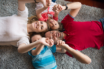 Image showing happy family lying on the floor