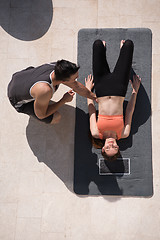 Image showing woman with personal trainer doing morning yoga exercises top vie