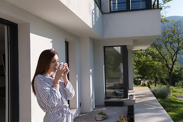 Image showing woman in a bathrobe enjoying morning coffee