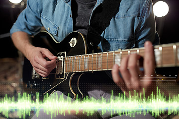 Image showing close up of man playing guitar at studio rehearsal