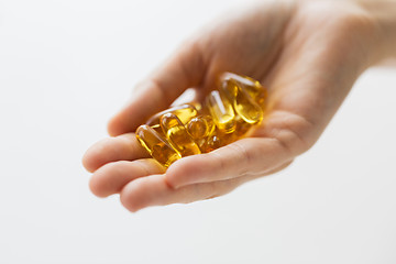 Image showing hand holding cod liver oil capsules