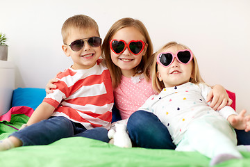 Image showing happy little kids in sunglasses at home