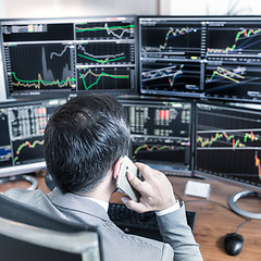 Image showing Over the shoulder view of computer screens and stock broker trading online.