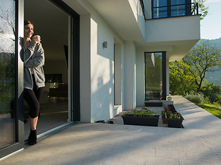 Image showing woman drinking coffee in front of her luxury home villa