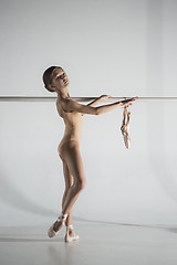 Image showing The girl is training near the ballet barre.