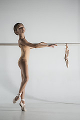 Image showing The girl is training near the ballet barre.