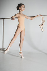 Image showing The girl is training near the ballet barre.