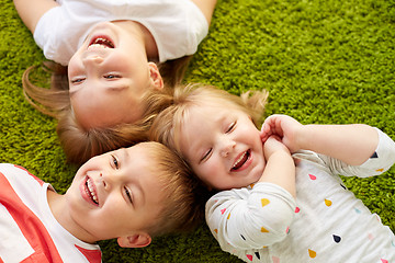 Image showing happy little kids lying on floor or carpet