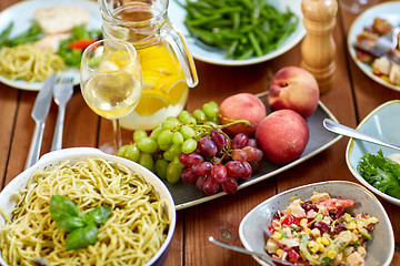 Image showing fruits, salads and pasta on wooden table