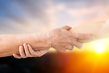 Image showing close up of senior and young woman holding hands