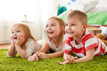 Image showing happy little kids lying on floor or carpet