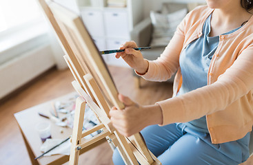 Image showing artist with brush painting at art studio