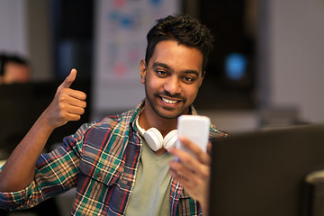 Image showing man with smartphone having video call at office