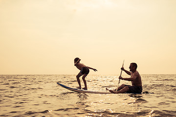 Image showing Father and son  playing on the beach at the day time.