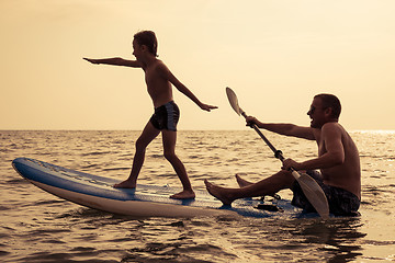 Image showing Father and son  playing on the beach at the day time.