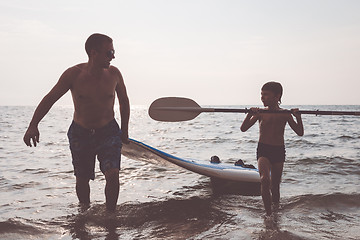 Image showing Father and son  playing on the beach at the day time.