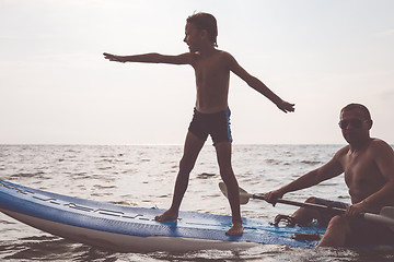 Image showing Father and son  playing on the beach at the day time.