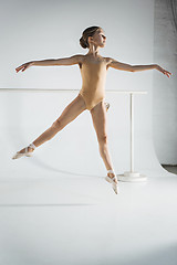 Image showing The girl is training near the ballet barre.