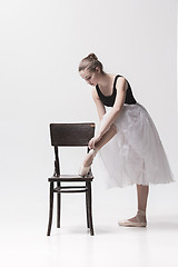 Image showing The teen ballerina in white pack posing near chair