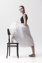 Image showing The teen ballerina in white pack posing near chair