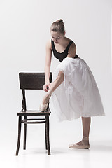 Image showing The teen ballerina in white pack posing near chair