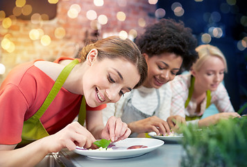 Image showing happy women cooking and decorating dishes