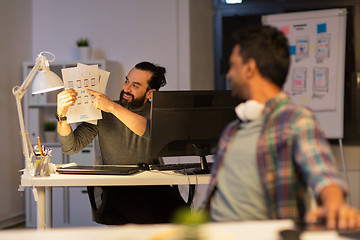 Image showing creative man showing papers to colleague at office