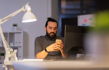 Image showing creative man with smartphone at night office