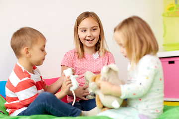 Image showing happy kids playing with plush toys at home