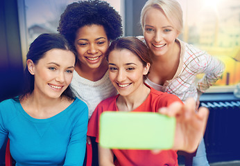 Image showing happy young women taking selfie with smartphone