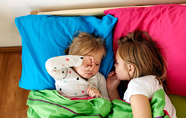 Image showing happy little girls sleeping in bed at home