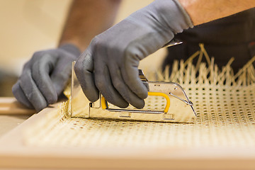 Image showing assembler with staple gun making furniture