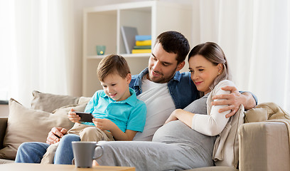 Image showing happy family with smartphone at home