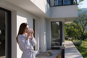 Image showing woman in a bathrobe enjoying morning coffee