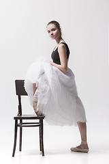 Image showing The teen ballerina in white pack posing near chair