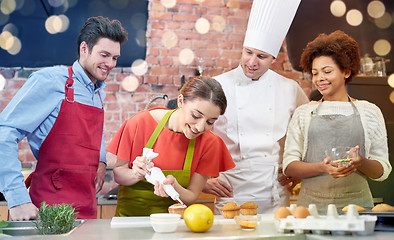 Image showing happy friends and chef cook baking in kitchen