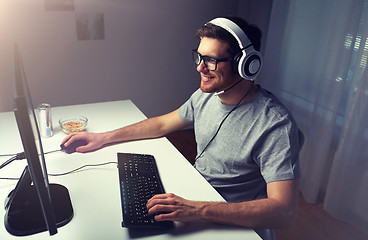 Image showing man in headset playing computer video game at home