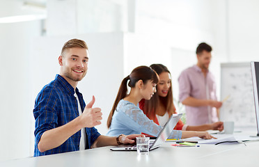 Image showing happy man with creative team at office conference