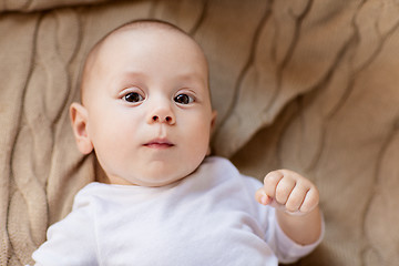 Image showing sweet little baby boy lying on knitted blanket