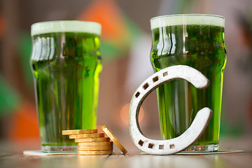 Image showing glass of green beer, horseshoe and gold coins