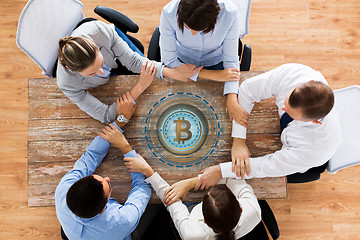 Image showing business team with bitcoin hologram holding hands