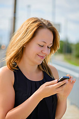 Image showing Young cheerful beautiful female using mobile phone