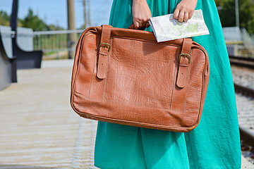 Image showing Girl in a holding a map and suitcase at station