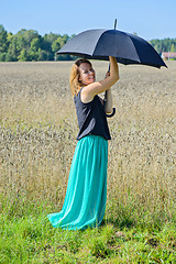 Image showing Portrait of woman with umbrella in field