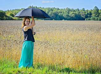 Image showing Portrait of woman with umbrella in field